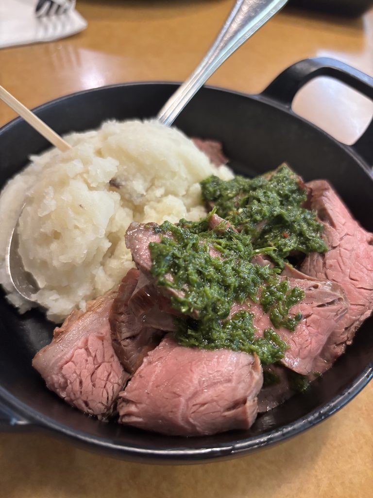 A skillet with beef and mashed potatoes. 